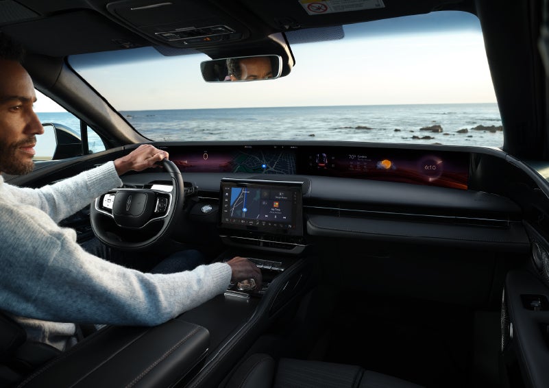 A driver of a parked 2024 Lincoln Nautilus® SUV takes a relaxing moment at a seaside overlook while inside his Nautilus. | Klaben Lincoln in Kent OH